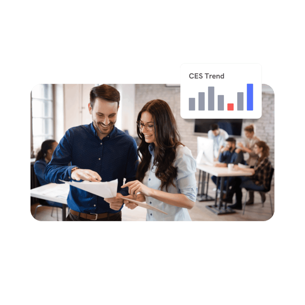 Two workers in an office reviewing a CES report with an example of a customer effort score trendline in the background