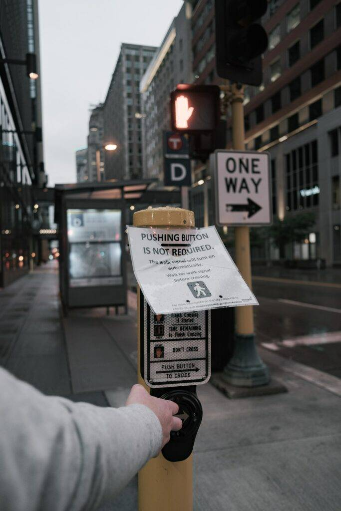 a person pressing the button at a pedestrian crossing