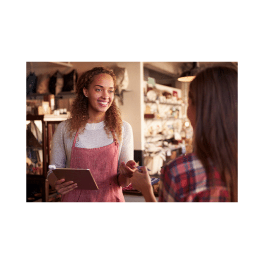 A women in a shop taking a card payment from a customer