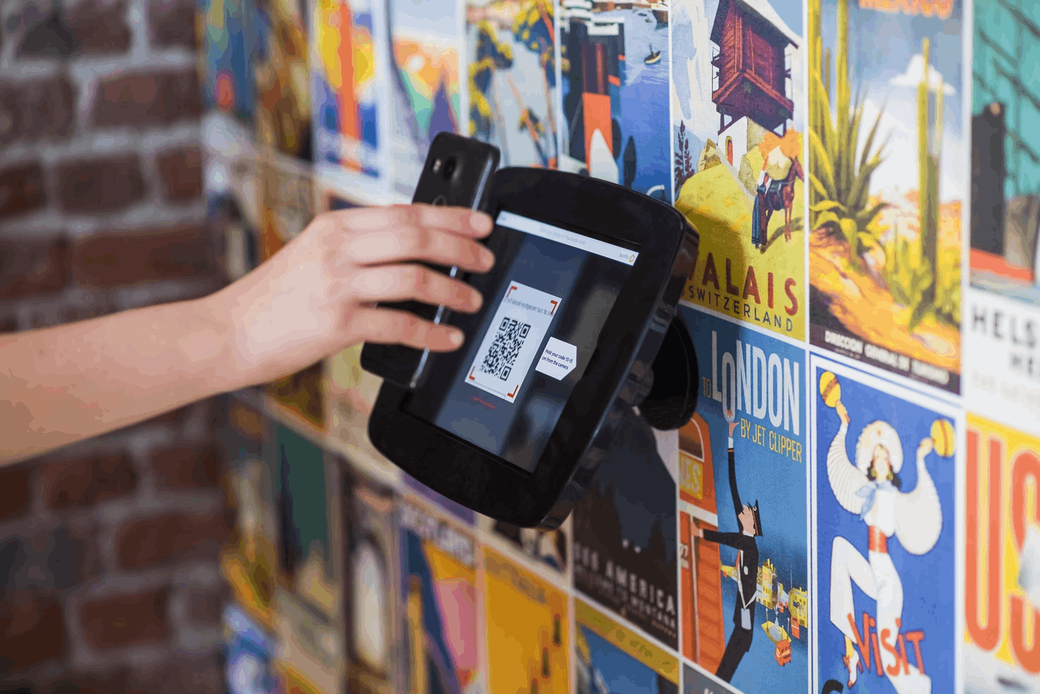 Person scanning a QR code with their phone to provide them (and the venue) with visitor information